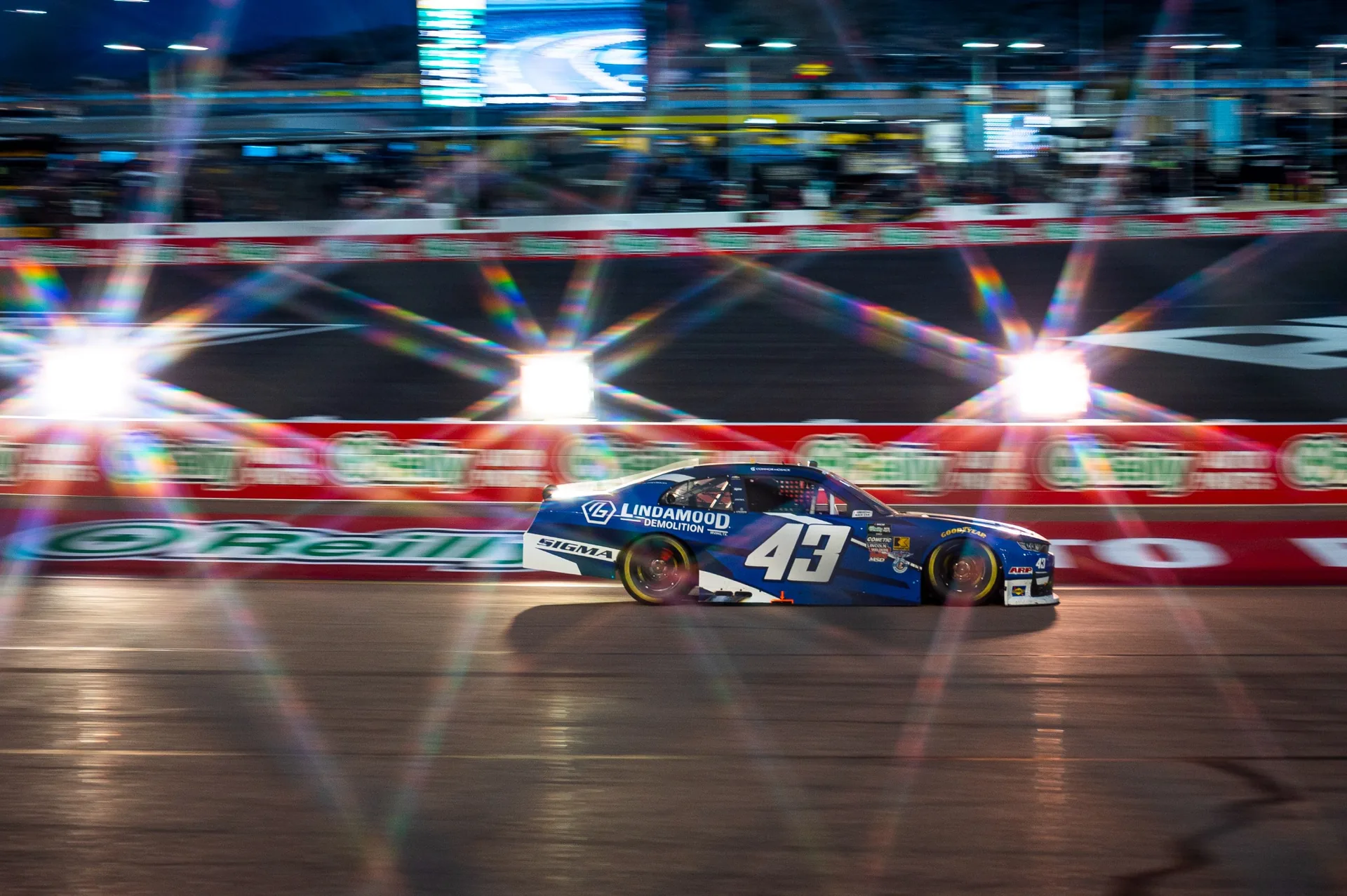 The No. 43 Lindamood Chevrolet races past illuminated grandstands at Phoenix Raceway.