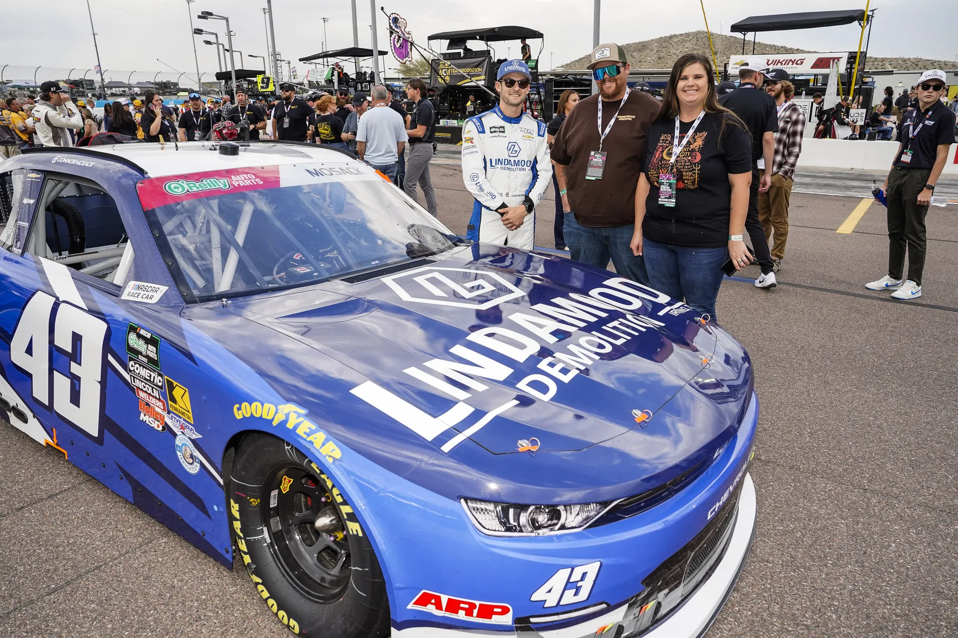 Connor Mosack and two people pose beside the No. 43 Lindamood Chevrolet at Phoenix Raceway.